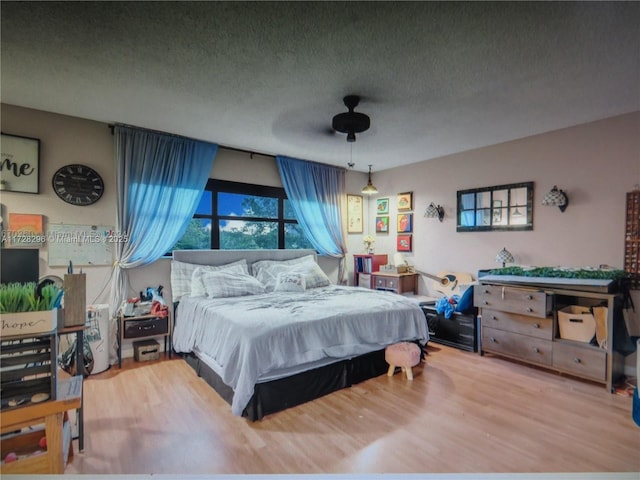 bedroom featuring a textured ceiling, ceiling fan, and hardwood / wood-style floors