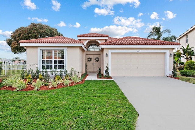 mediterranean / spanish house featuring a garage and a front yard