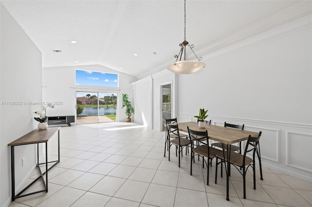 tiled dining space featuring a textured ceiling and lofted ceiling