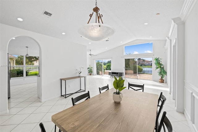 tiled dining area with ceiling fan and lofted ceiling