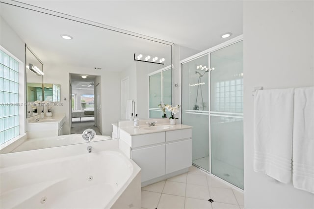 bathroom with ceiling fan, a healthy amount of sunlight, independent shower and bath, and vanity