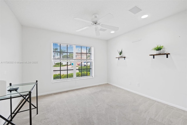 carpeted spare room with ceiling fan