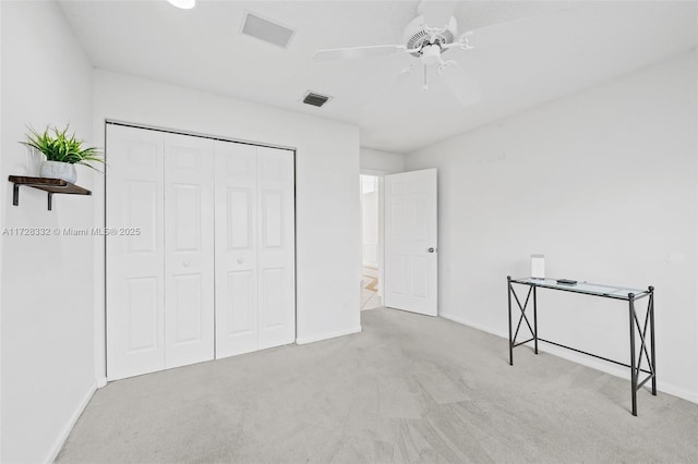 unfurnished bedroom with light carpet, ceiling fan, and a closet