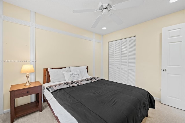 carpeted bedroom with ceiling fan and a closet