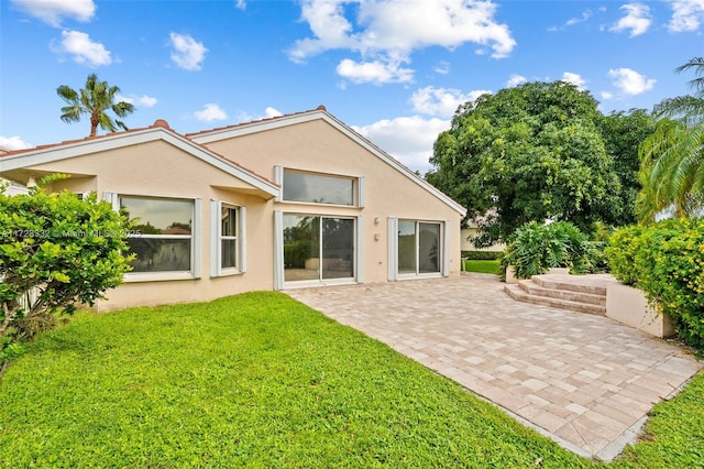 rear view of house featuring a yard and a patio