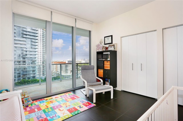 interior space with a wall of windows, plenty of natural light, and dark tile patterned floors