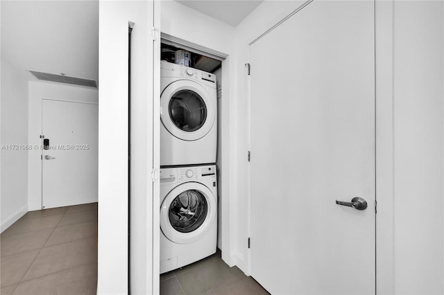 washroom featuring tile patterned floors and stacked washing maching and dryer