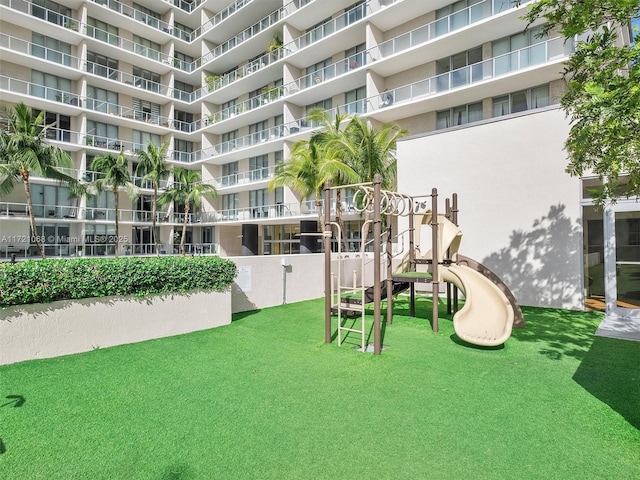 view of home's community featuring a lawn and a playground