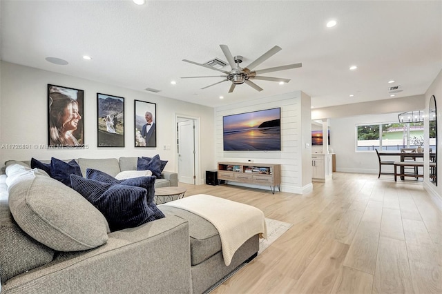 living room with light hardwood / wood-style floors and ceiling fan