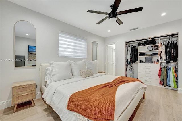 bedroom with ceiling fan, light hardwood / wood-style floors, and a closet