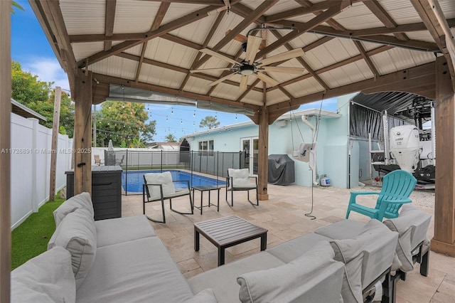 view of patio / terrace with a gazebo, an outdoor hangout area, a fenced in pool, ceiling fan, and grilling area