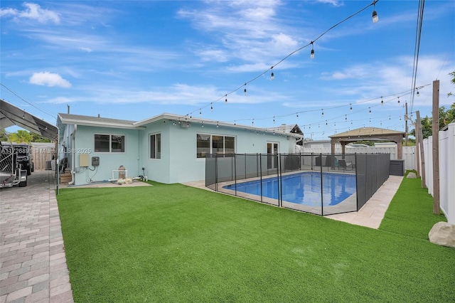 rear view of property with a fenced in pool, a gazebo, a lawn, and a patio