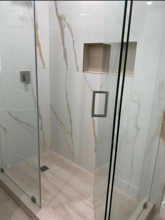 bathroom featuring a shower with shower door