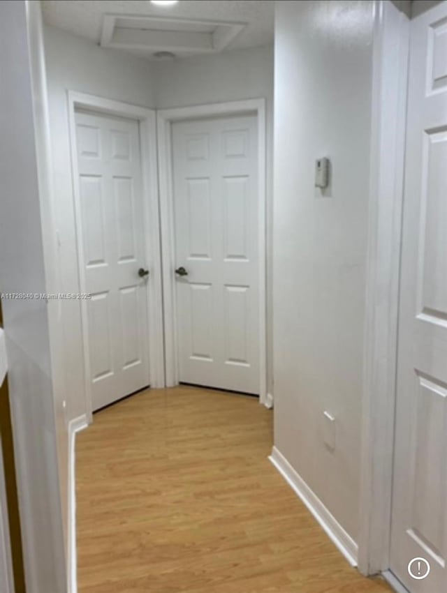 hallway with light hardwood / wood-style floors