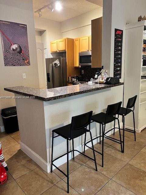 kitchen featuring a breakfast bar, kitchen peninsula, and stainless steel appliances