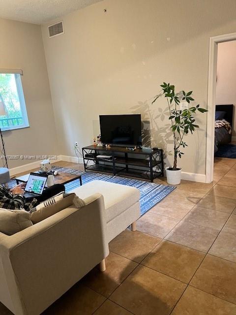 living room with a textured ceiling and tile patterned flooring