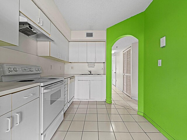 kitchen with a textured ceiling, white range with electric stovetop, white cabinetry, and sink