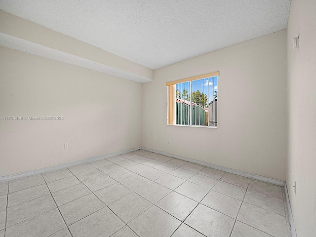 unfurnished room featuring a textured ceiling and light tile patterned floors