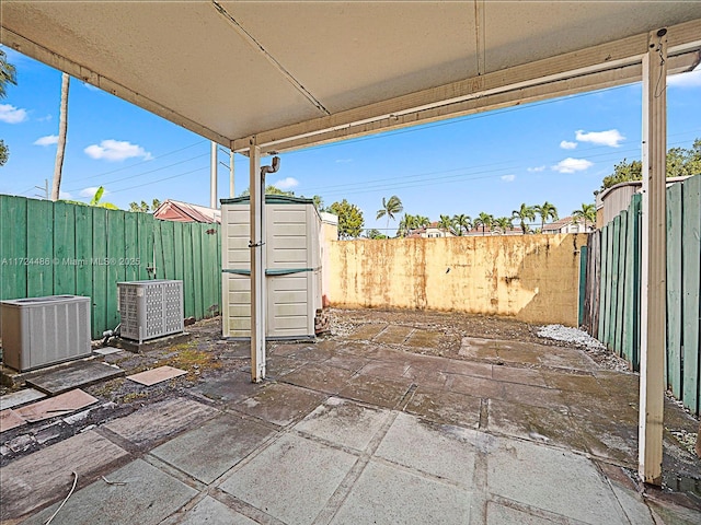 view of patio with central AC and a storage shed