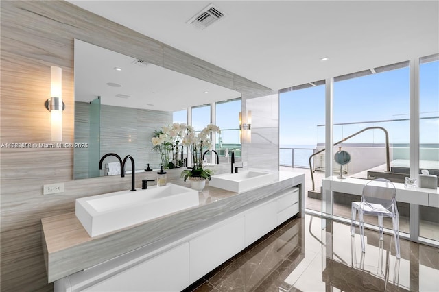 bathroom featuring vanity, expansive windows, and a water view