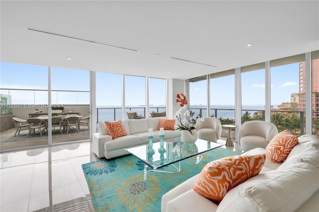 living room with light tile patterned floors, a wall of windows, and a water view