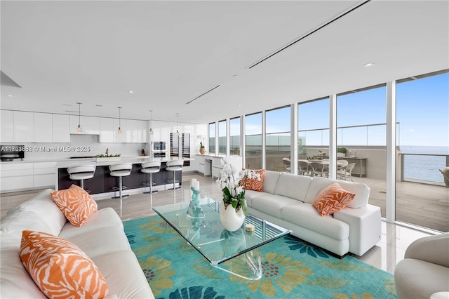 living room with a water view, a wall of windows, and a wealth of natural light