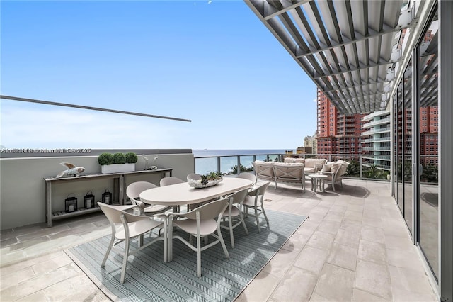 view of patio / terrace with a water view, a balcony, and outdoor lounge area