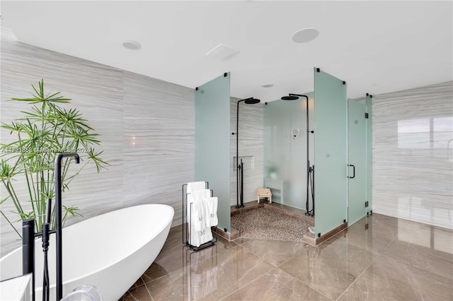 bathroom featuring tile walls and independent shower and bath