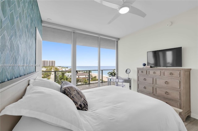 bedroom featuring expansive windows, ceiling fan, hardwood / wood-style floors, and access to outside