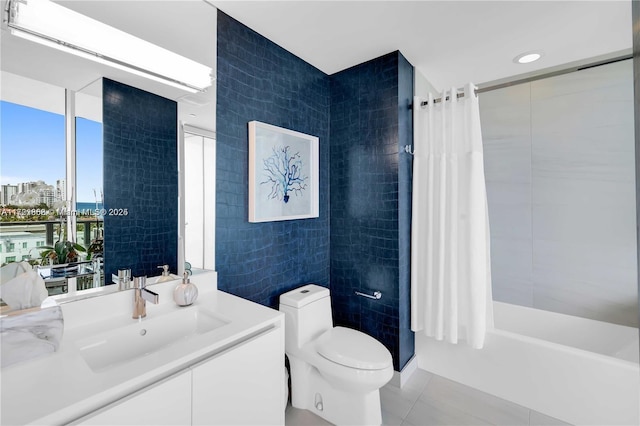 full bathroom featuring tile walls, shower / tub combo, vanity, tile patterned floors, and toilet