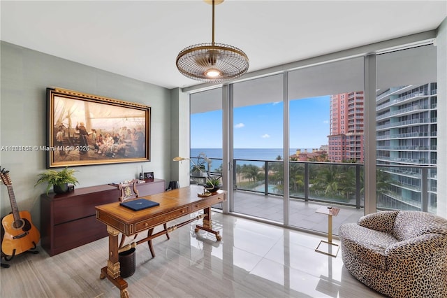 office area with expansive windows, a water view, and light tile patterned floors