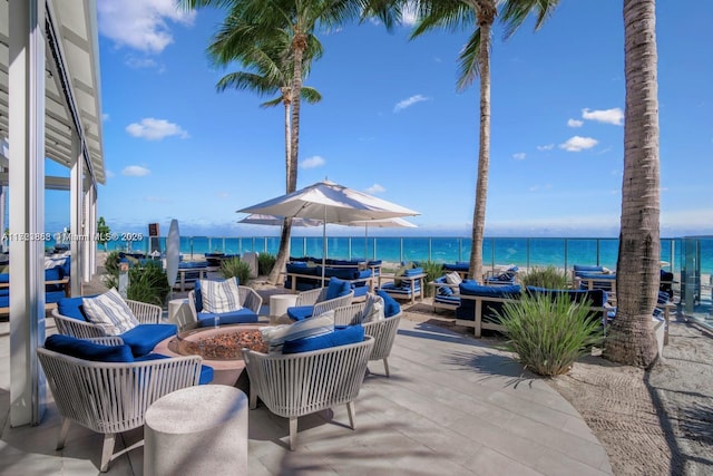 view of patio / terrace featuring a water view and an outdoor living space with a fire pit