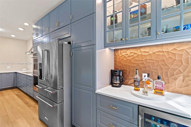 kitchen featuring high end refrigerator, wine cooler, light wood-type flooring, black electric cooktop, and blue cabinets