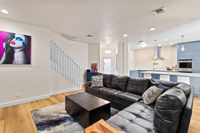 living room featuring a textured ceiling and light wood-type flooring