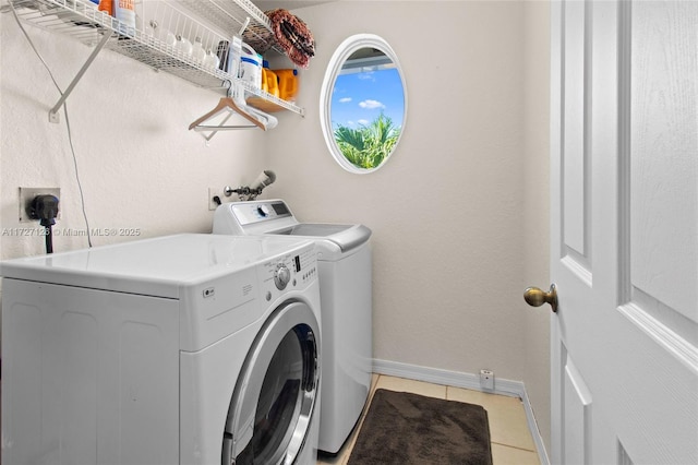 washroom featuring light tile patterned floors and washer and clothes dryer