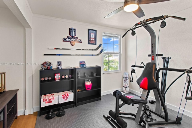 workout area featuring a textured ceiling, ceiling fan, and ornamental molding