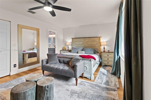 bedroom with ceiling fan, ensuite bath, and light wood-type flooring