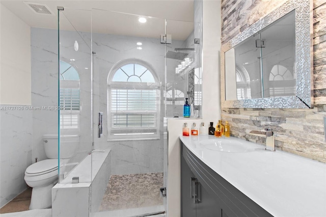 bathroom featuring a shower with shower door, toilet, and vanity