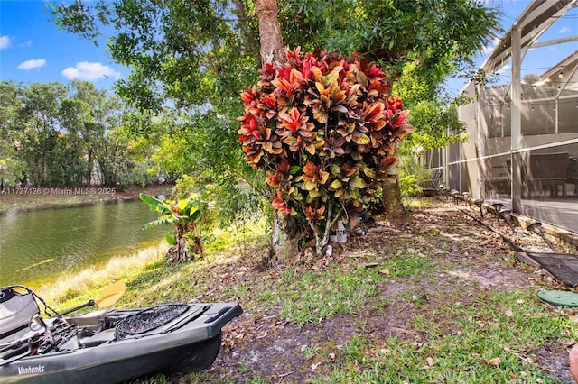 view of yard with a lanai and a water view