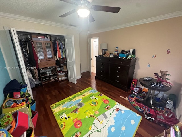 bedroom with ceiling fan, dark hardwood / wood-style floors, a closet, and crown molding