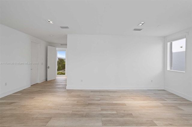 empty room featuring a healthy amount of sunlight and light wood-type flooring