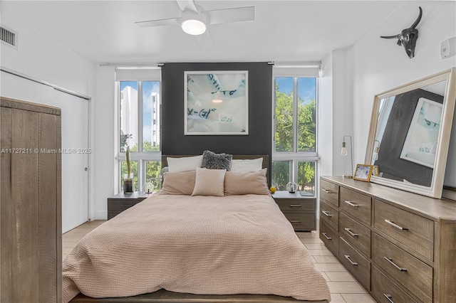 bedroom featuring ceiling fan, a closet, and multiple windows