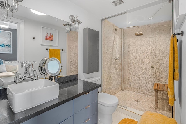 bathroom featuring toilet, a tile shower, tile patterned floors, and vanity