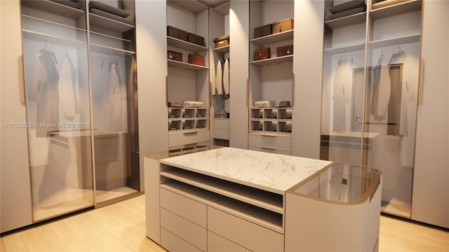 walk in closet with light hardwood / wood-style floors