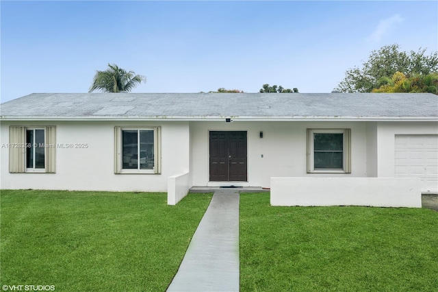 ranch-style house featuring a front lawn and a garage