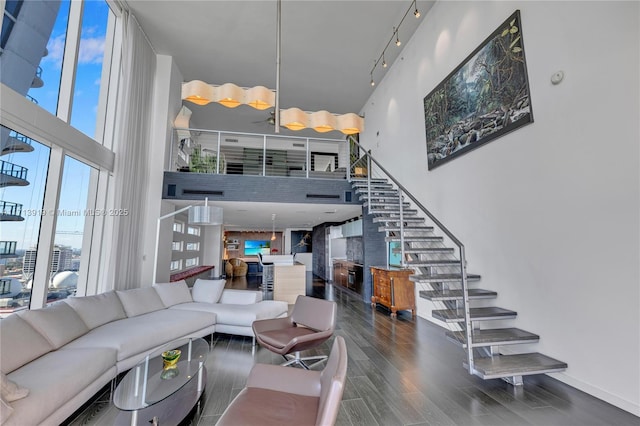 living room featuring a towering ceiling and wood-type flooring