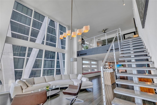 living room featuring ceiling fan, a high ceiling, and hardwood / wood-style flooring