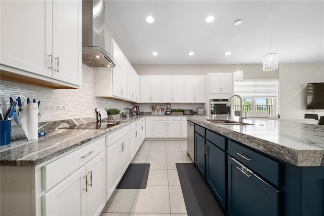 kitchen featuring white cabinetry, tasteful backsplash, hanging light fixtures, wall chimney exhaust hood, and sink