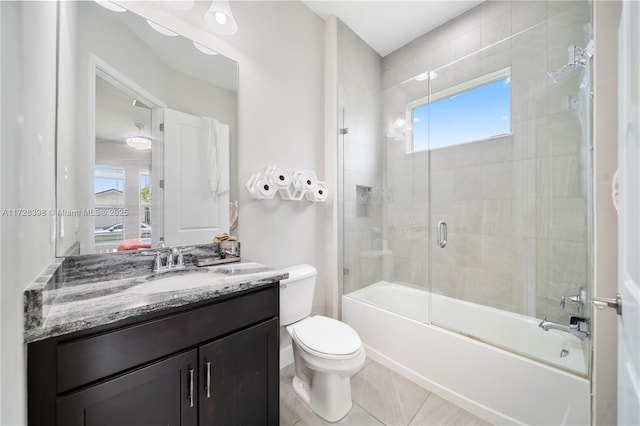 full bathroom featuring bath / shower combo with glass door, tile patterned floors, vanity, and toilet