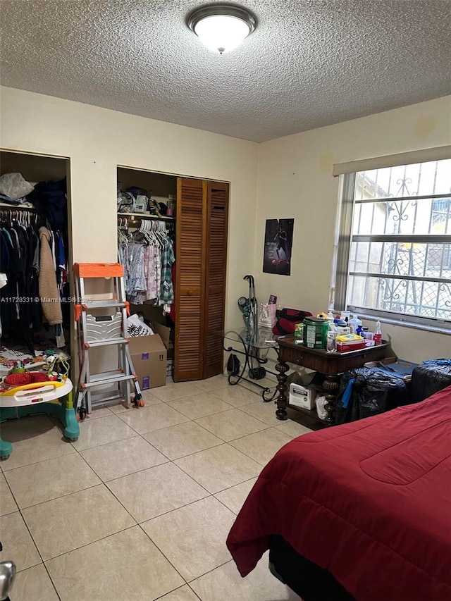 bedroom featuring a textured ceiling, a closet, and tile patterned floors